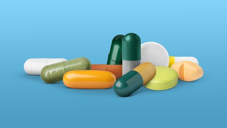 Image of Different antibiotic pills on light blue background. Banner design