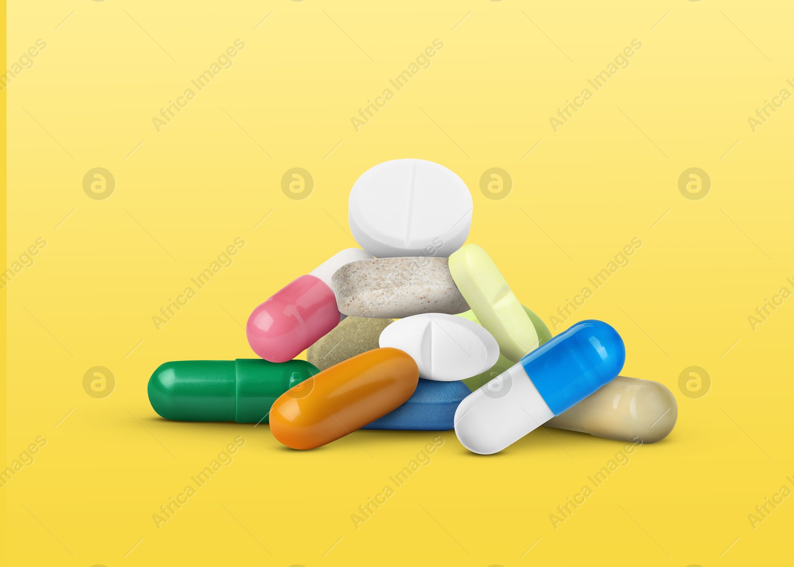Many different antibiotic pills on yellow gradient background Image of Many different antibiotic pills on yellow gradient background