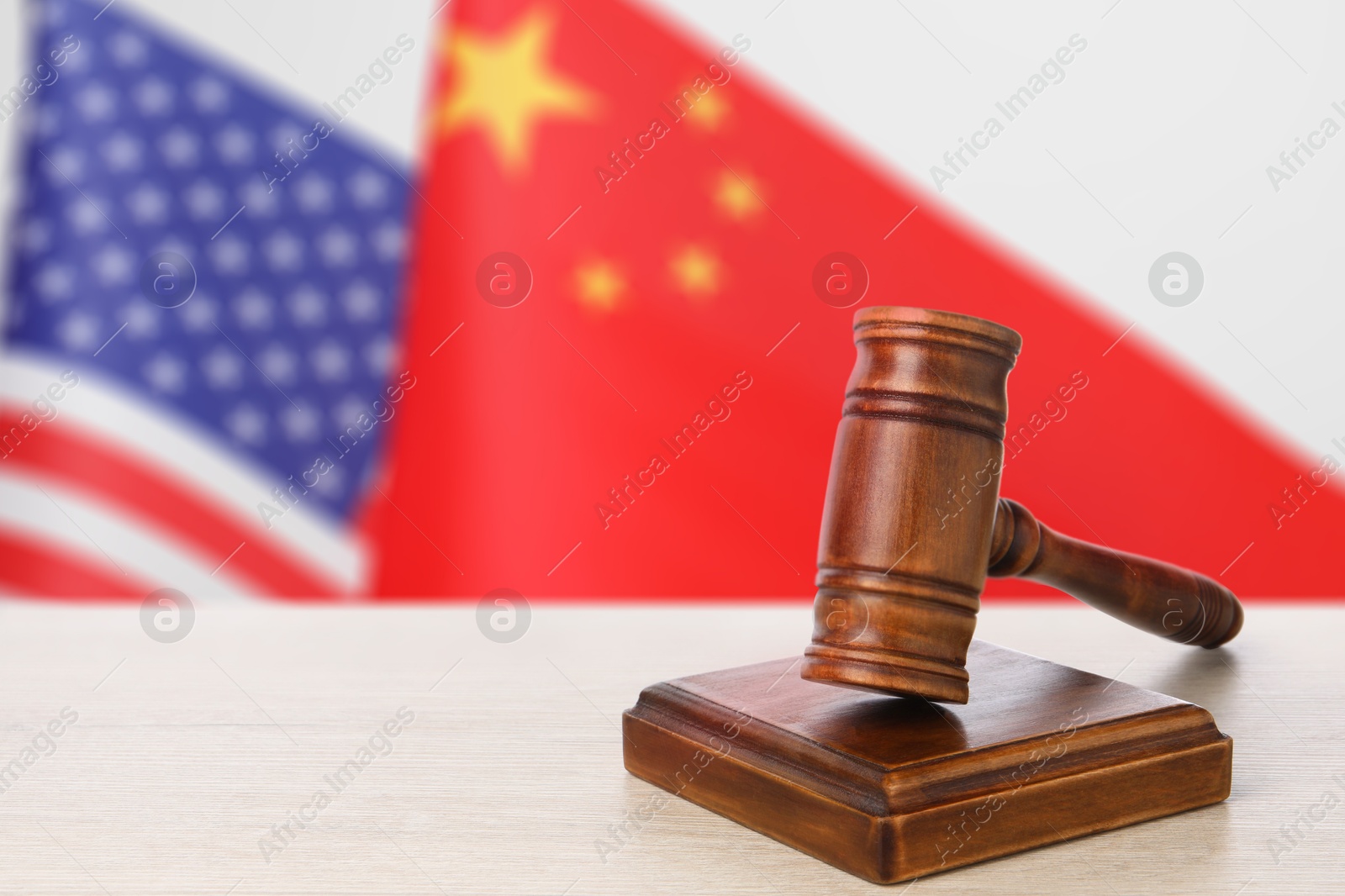 Judge's gavel on wooden table against flags of USA and China Image of Judge's gavel on wooden table against flags of USA and China