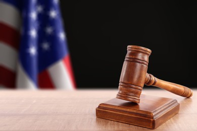 Image of Judge's gavel on wooden table against flag of USA