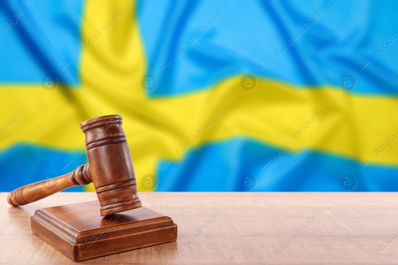 Judge's gavel on wooden table against flag of Sweden Image of Judge's gavel on wooden table against flag of Sweden