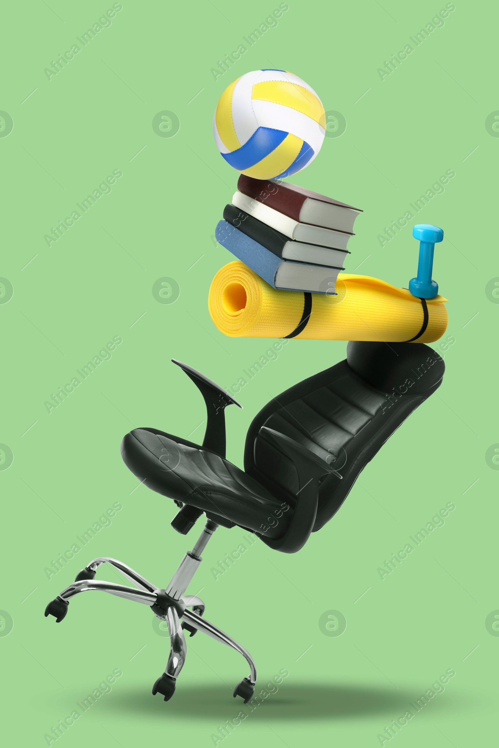 Work-life balance. Tower of volleyball ball, books, mat, dumbbell and office chair on light green background Image of Work-life balance. Tower of volleyball ball, books, mat, dumbbell and office chair on light green background