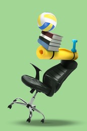 Image of Work-life balance. Tower of volleyball ball, books, mat, dumbbell and office chair on light green background