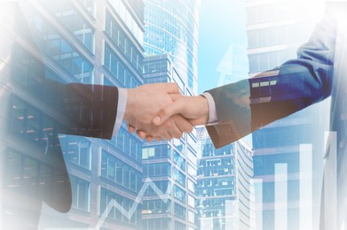 Image of Businesspeople shaking hands, cityscape and graph, multiple exposure. Deal or partnership concept