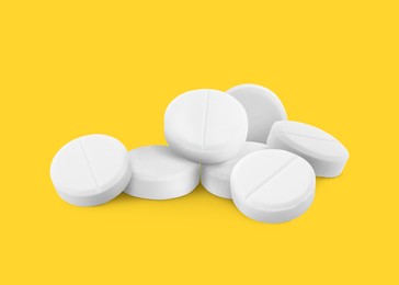 Image of Antibiotic pills. Round white tablets on orange background