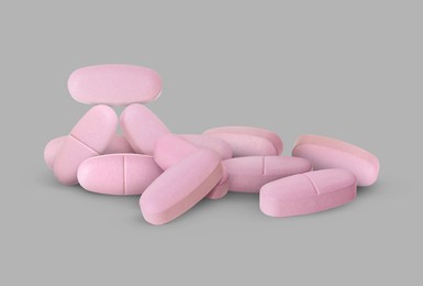 Image of Antibiotic pills. Oval pink tablets on grey background