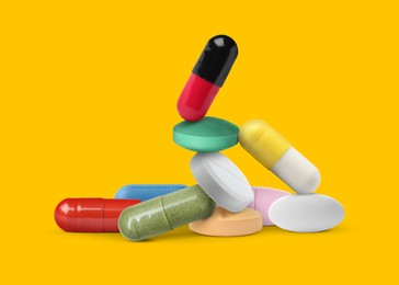 Image of Many different antibiotic pills on orange background