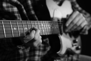 Image of Woman playing guitar in darkness, closeup. Black and white effect