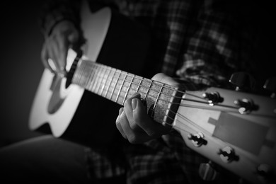 Image of Woman playing guitar in darkness, closeup. Black and white effect