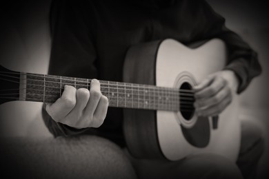 Image of Man playing guitar, closeup. Black and white effect