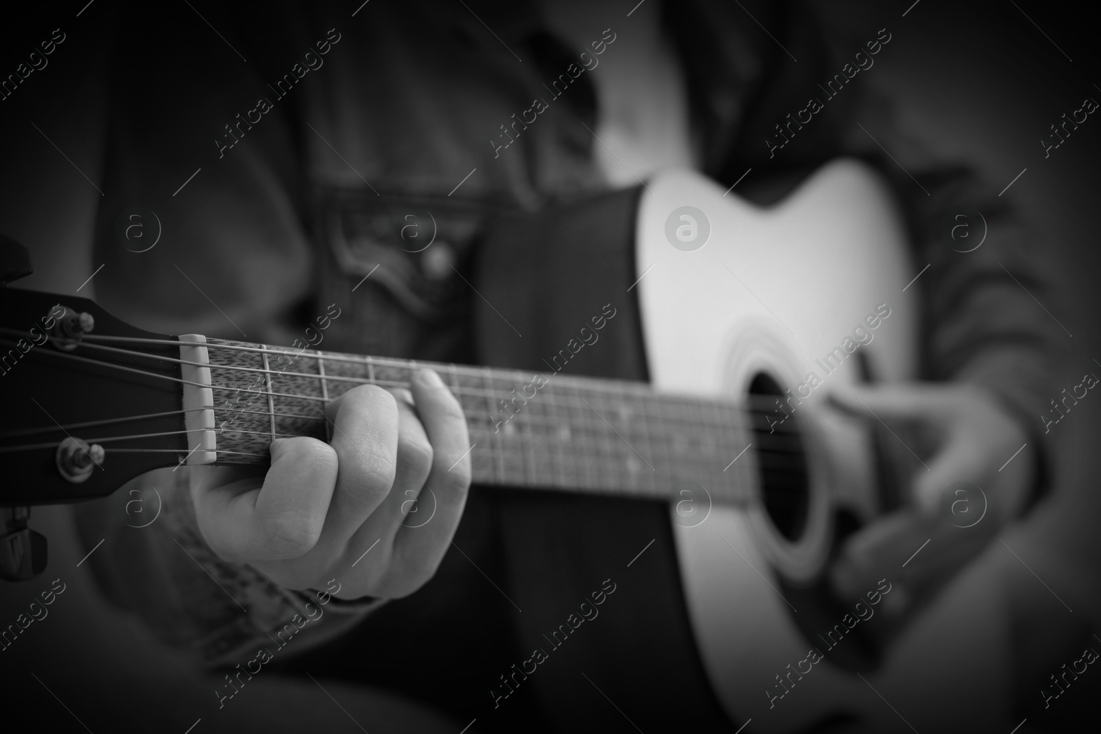 Man playing guitar, closeup. Black and white effect Image of Man playing guitar, closeup. Black and white effect