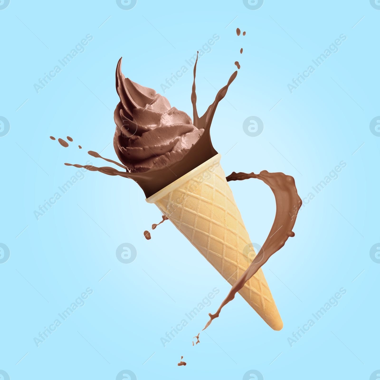 Chocolate ice cream in waffle cone and splash of milk in air on light blue background Image of Chocolate ice cream in waffle cone and splash of milk in air on light blue background