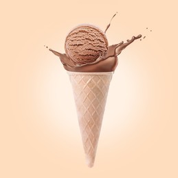 Image of Chocolate ice cream in waffle cone and splash of milk on beige background