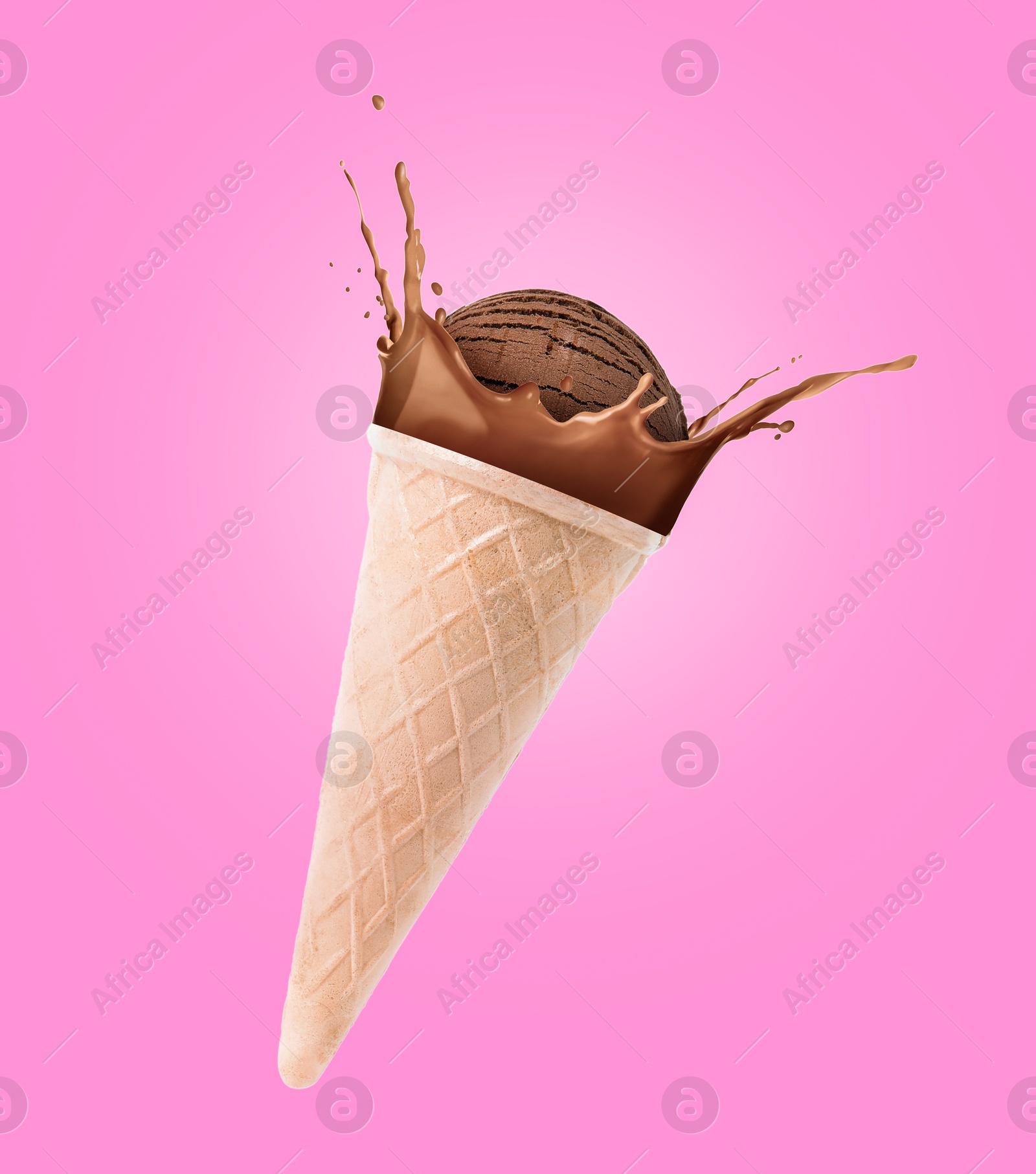 Chocolate ice cream in waffle cone and splash of milk in air on pink background Image of Chocolate ice cream in waffle cone and splash of milk in air on pink background