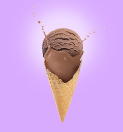 Image of Chocolate ice cream in waffle cone and splash of milk on violet background