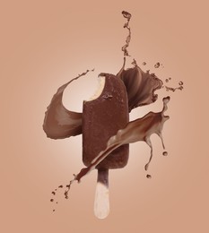 Image of Chocolate ice cream bar and splash of milk on pale brown background