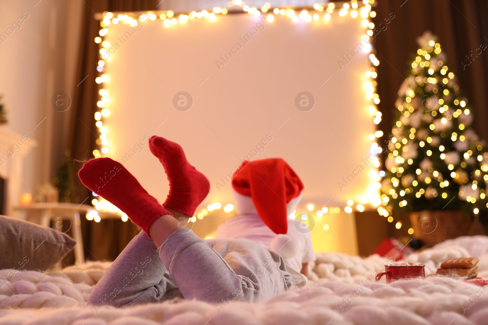 Child watching movie using video projector at home. Cozy Christmas atmosphere Photo of Child watching movie using video projector at home. Cozy Christmas atmosphere