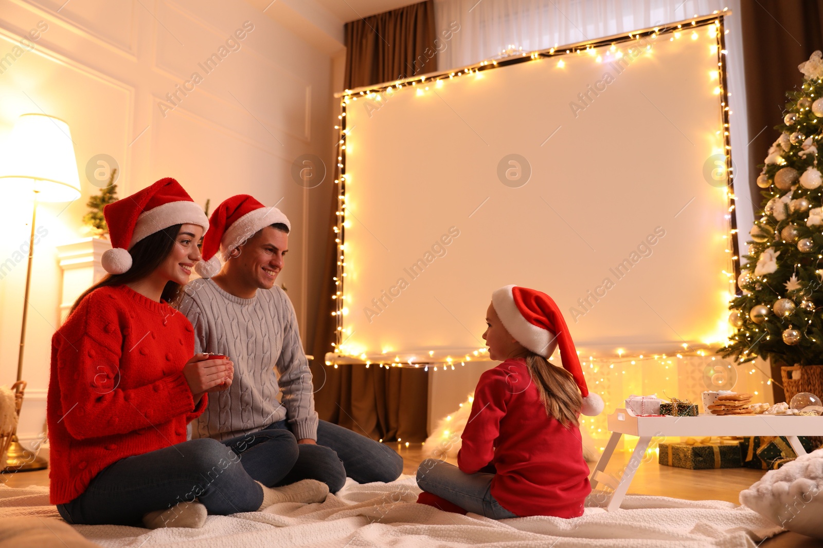 Family near video projector screen at home. Christmas time Photo of Family near video projector screen at home. Christmas time