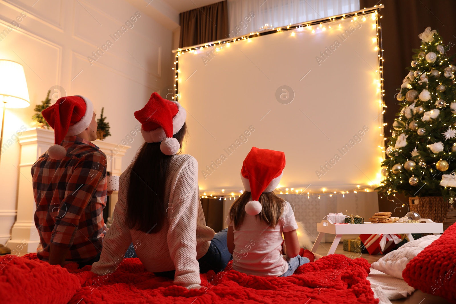 Family watching movie using video projector at home. Cozy Christmas atmosphere Photo of Family watching movie using video projector at home. Cozy Christmas atmosphere