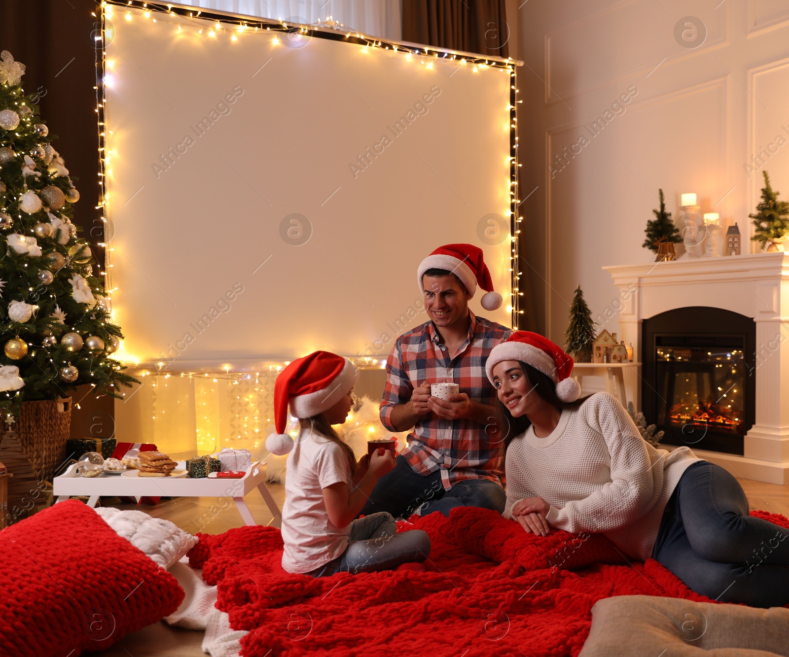 Photo of Father and daughter near video projector screen at home. Cozy Christmas atmosphere