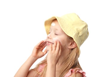 Photo of Smiling little girl applying sun protection cream onto her skin against white background