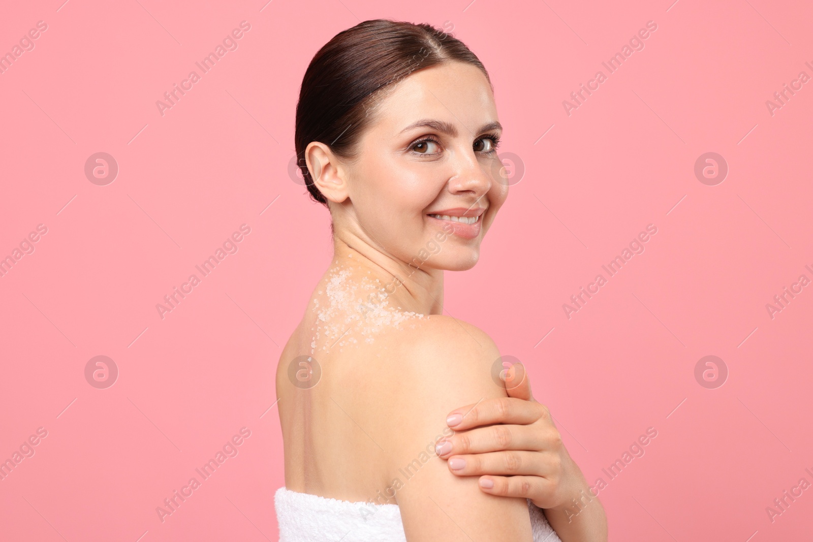 Smiling woman with body scrub on her skin against pink background Photo of Smiling woman with body scrub on her skin against pink background