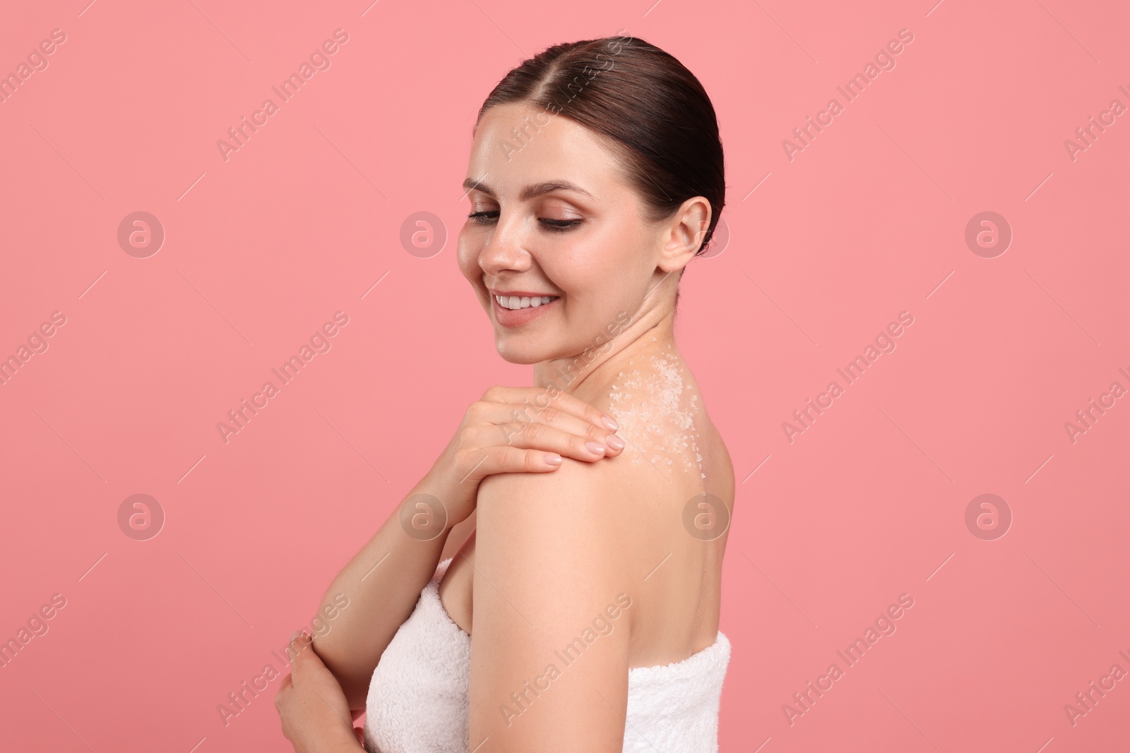 Smiling woman with body scrub on her skin against pink background Photo of Smiling woman with body scrub on her skin against pink background