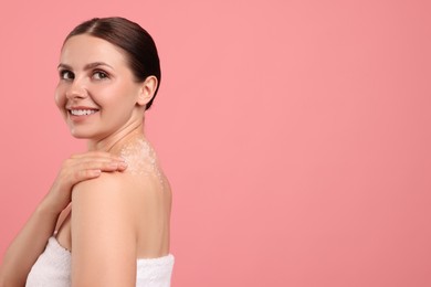 Photo of Smiling woman with body scrub on her skin against pink background. Space for text