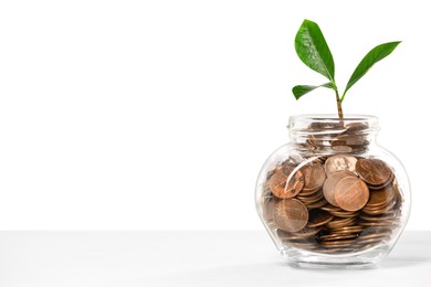 Photo of Investment concept. Glass jar with coins and sprout on light background, space for text