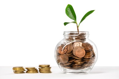 Photo of Investment concept. Glass jar with coins and sprout on light background, space for text