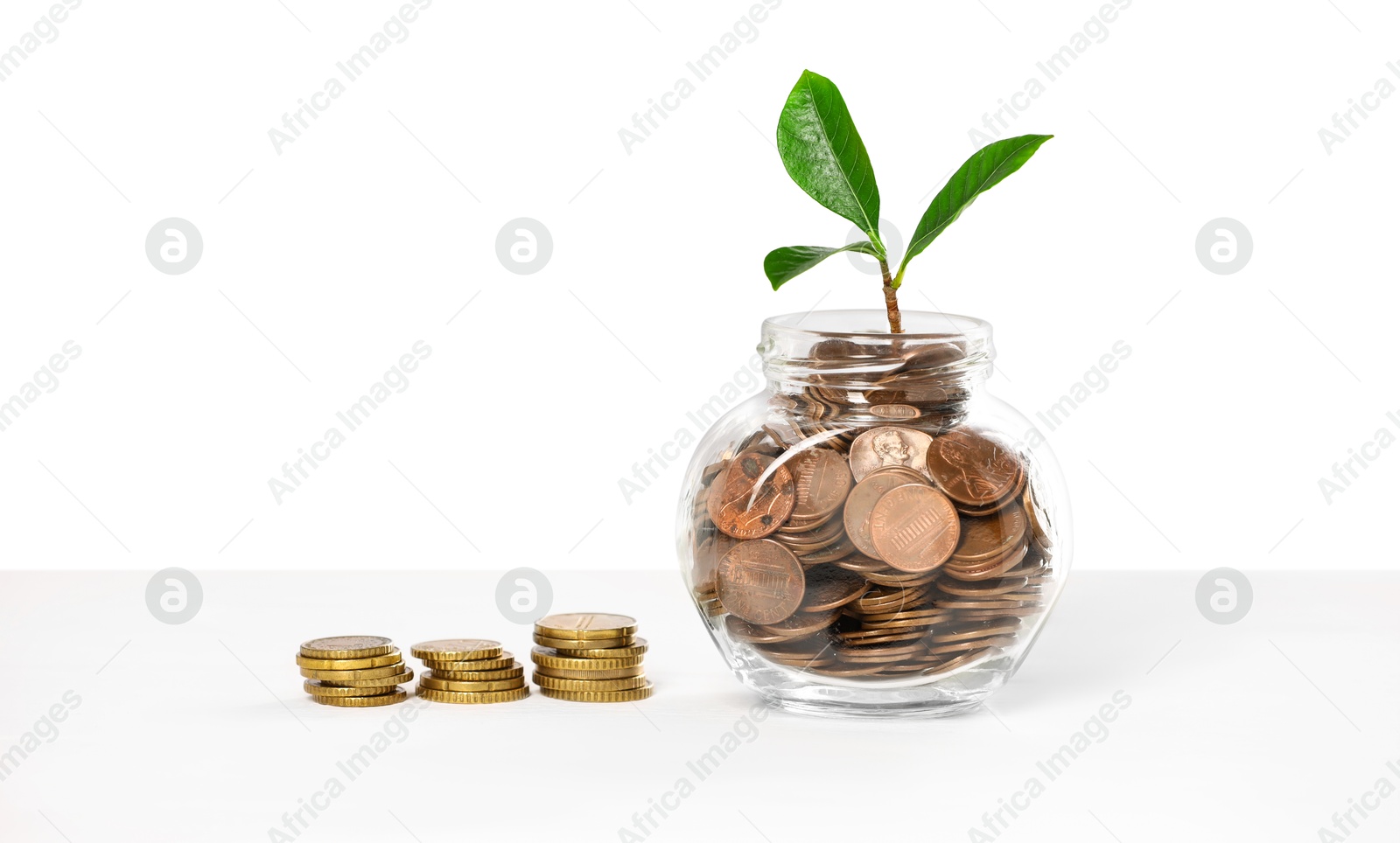 Investment concept. Glass jar with coins and sprout on light background, space for text Photo of Investment concept. Glass jar with coins and sprout on light background, space for text
