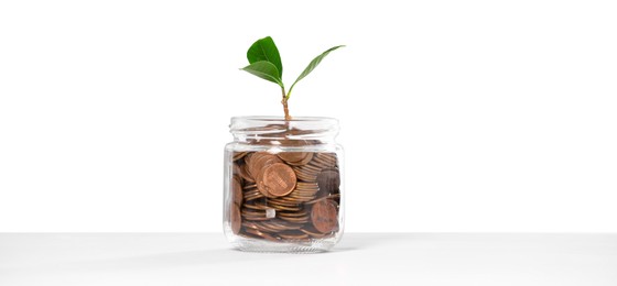Photo of Investment concept. Glass jar with coins and sprout on light background