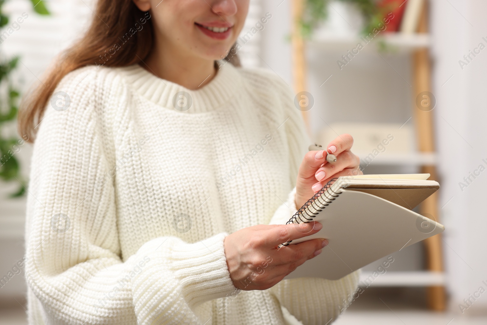 Woman writing in planner at home, closeup Photo of Woman writing in planner at home, closeup