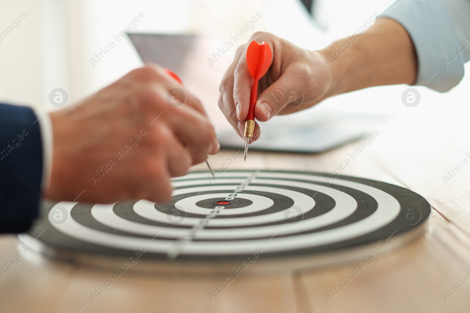 Photo of Men with darts aiming at dartboard indoors, closeup