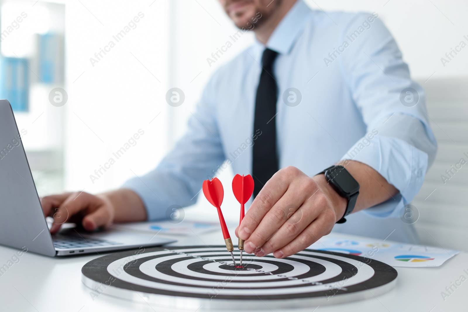 Man with dart aiming at dartboard while working indoors, closeup Photo of Man with dart aiming at dartboard while working indoors, closeup