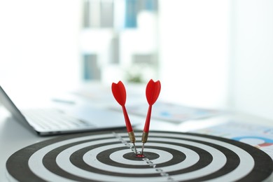 Photo of Dartboard with arrow on table indoors, closeup