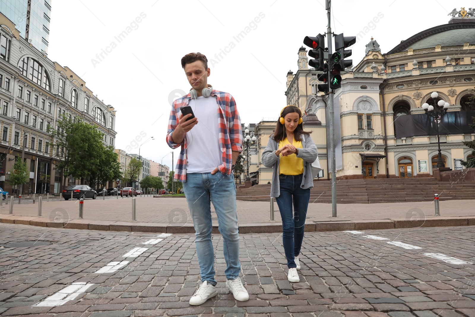 Photo of Young people crossing street at traffic lights