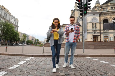 Photo of Young people crossing street at traffic lights