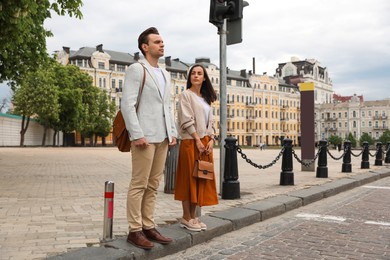 Photo of Young people waiting at traffic lights to cross street