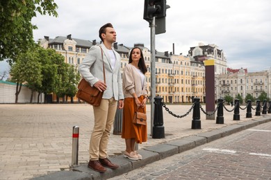 Photo of Young people waiting at traffic lights to cross street