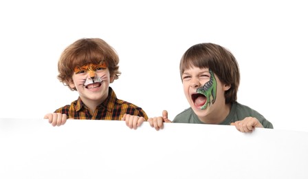 Photo of Cute boys with colorful face paintings and blank banner on white background. Space for text