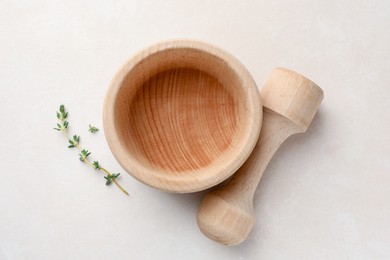 Photo of Wooden mortar, pestle and thyme on white table, flat lay