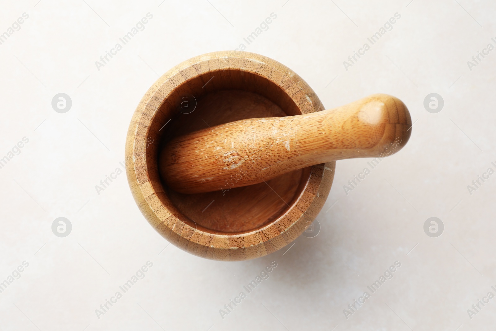 Wooden mortar and pestle on white table, top view Photo of Wooden mortar and pestle on white table, top view