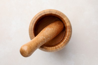 Photo of Wooden mortar and pestle on white table, top view