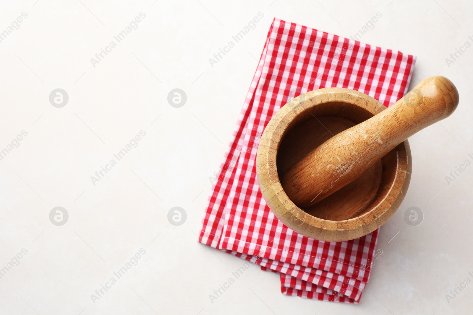 Wooden mortar, pestle and cloth on white table, top view. Space for text Photo of Wooden mortar, pestle and cloth on white table, top view. Space for text