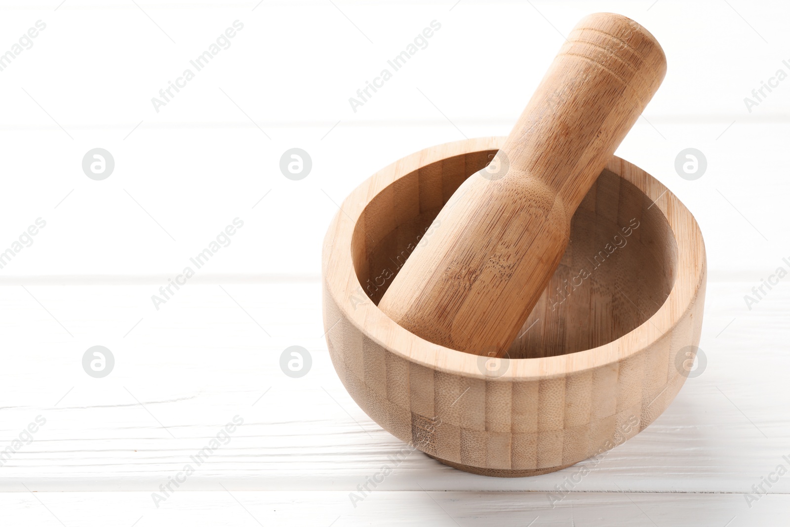 Mortar and pestle on white wooden table, closeup. Space for text Photo of Mortar and pestle on white wooden table, closeup. Space for text
