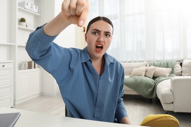 Photo of Shocked young woman holding cockroach indoors. Pest problem