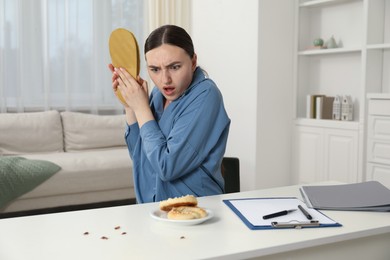 Photo of Emotional young woman with slipper looking in disgust at cockroaches indoors. Pest problem