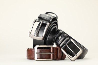 Photo of Three color leather belts on white background, space for text