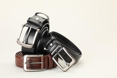 Photo of Three color leather belts on white background, space for text